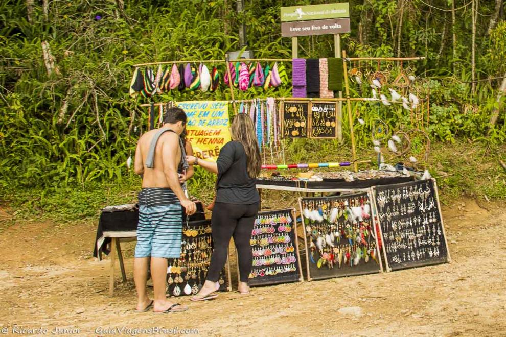 Imagem de um turistas comprando artesanatos na Cachoeira do Escorrega.